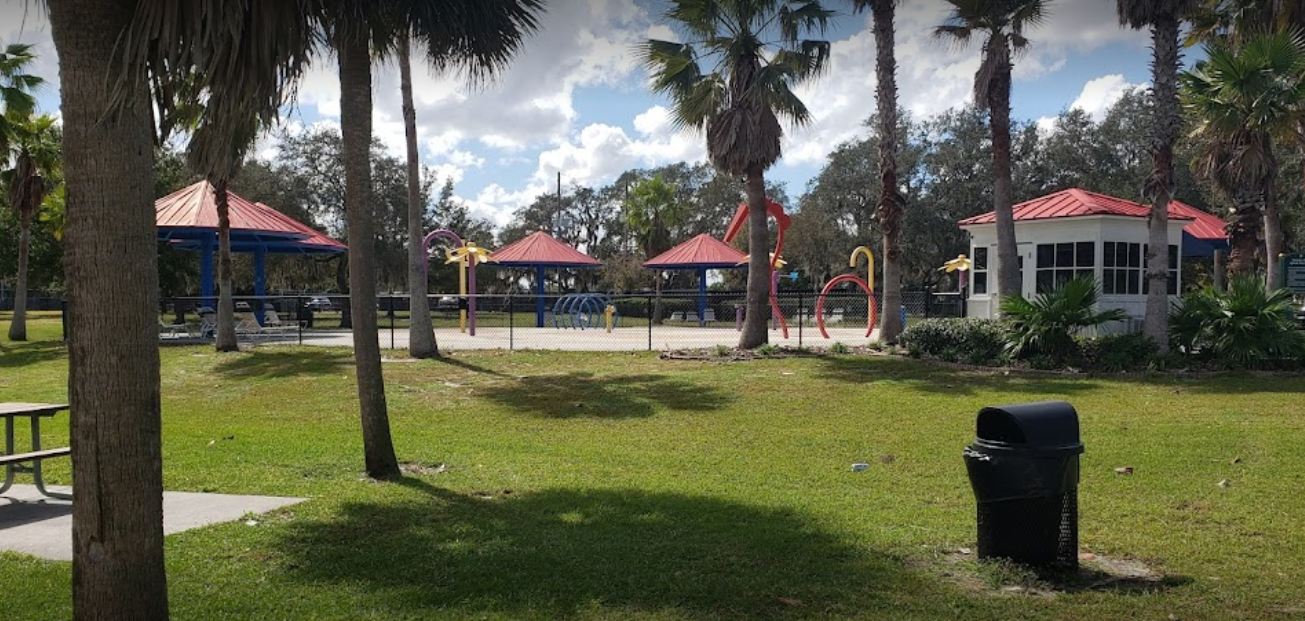 Downey Dog Park with covered pavilions palm trees and playground area in Orlando Florida
